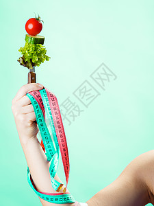 传播学家日饮食和减肥概念糖尿病女手与素食和彩色的测量磁带绿色蓝背景背景