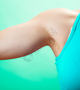 适合瘦女人的身体概念工作室蓝绿色背景的女手臂图片