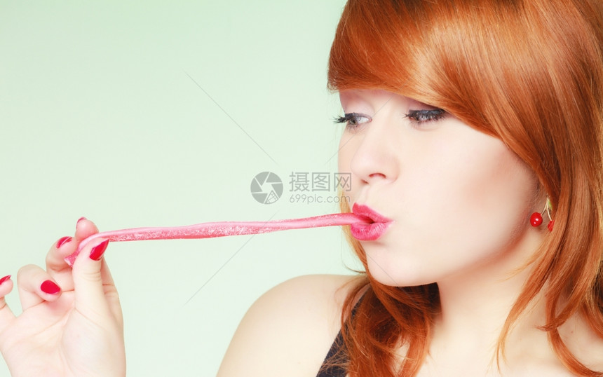 拿着糖果的感年轻女人红发可爱的女孩绿色甜果酱图片