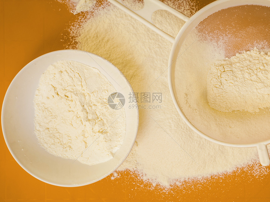 烹饪概念准备烘烤原料和烹饪工具以做蛋糕在橙子非棒硅酮垫上筛选面粉最高视图图片