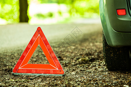 汽车运输转的分布红色警告三角标志的关闭在森林道路上图片