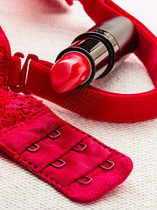化妆品在红蕾丝胸罩内衣上提供口红嘴唇优雅的化妆品图片