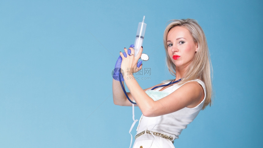 有听诊镜和注射器蓝色背景的护士服妇女图片