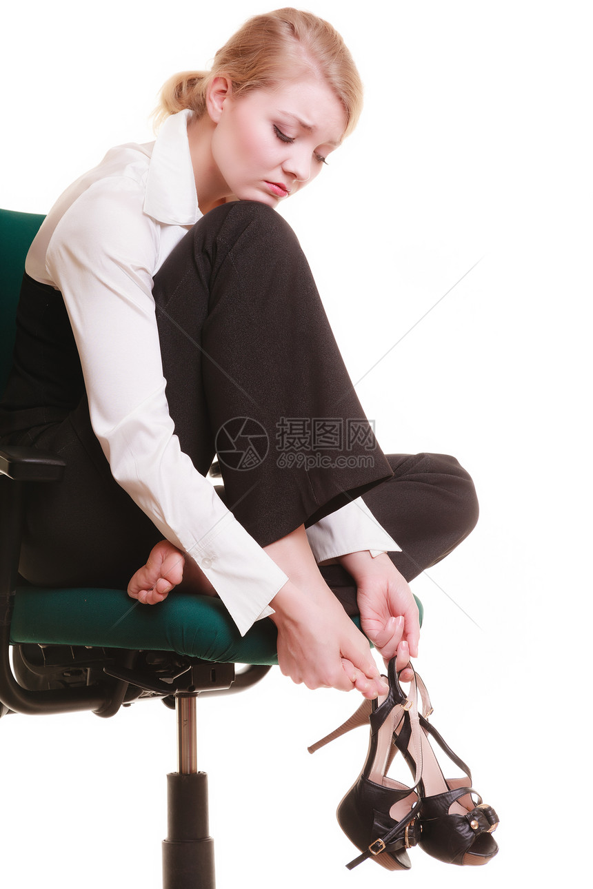 女商人脚痛累年轻女用白椅子按摩她的脚图片