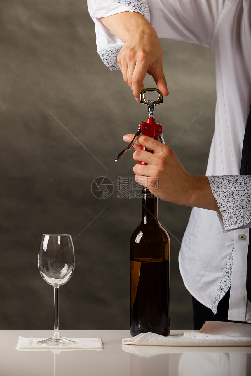 男服务员开瓶酒与corkscrew开瓶酒图片