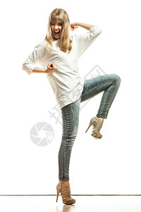 时装年轻女牛仔裤白袖高跟鞋全时庆祝成功举臂的女模范图片