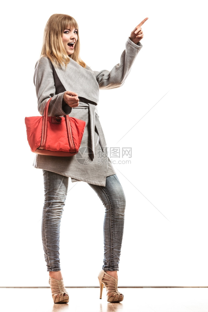 时装和广告饰TFull身女子优雅的灰色皮带外套上面拿着红色手袋指空的间图片