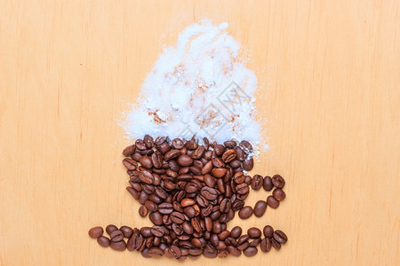 卡布奇诺时间烤咖啡豆以木质表面背景上白霜的杯子和碟形式包装成烤咖啡豆图片
