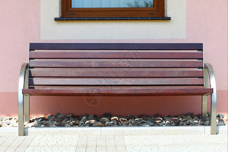 粉红色墙壁背景现代房屋的木制花园椅图片