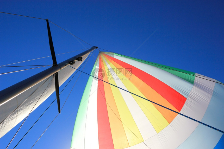 风把帆船上的脊柱装满了风向深蓝天空的彩色航行详情图片