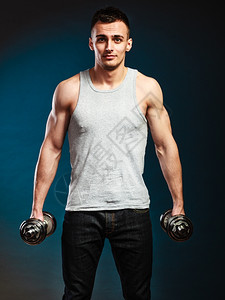 健壮体体壮的人与哑铃一起锻炼运动肌肉帅的家伙举重黑暗背景图片