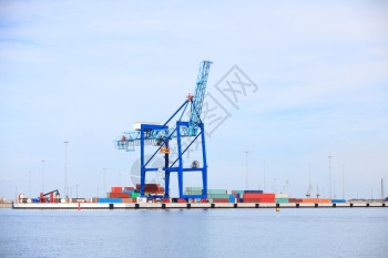 工业港口货物起重机和集装箱载卸蓝天背景图片