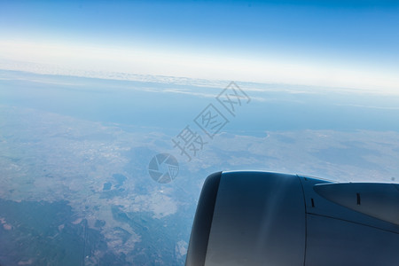 蓝天空和引擎从云中飞行的机窗口查看天景云色Bird39眼睛图片