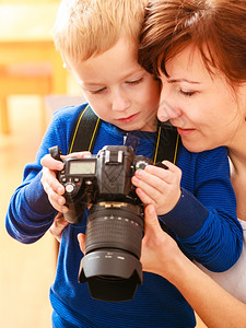 母亲和儿子玩相机在家里拍照图片