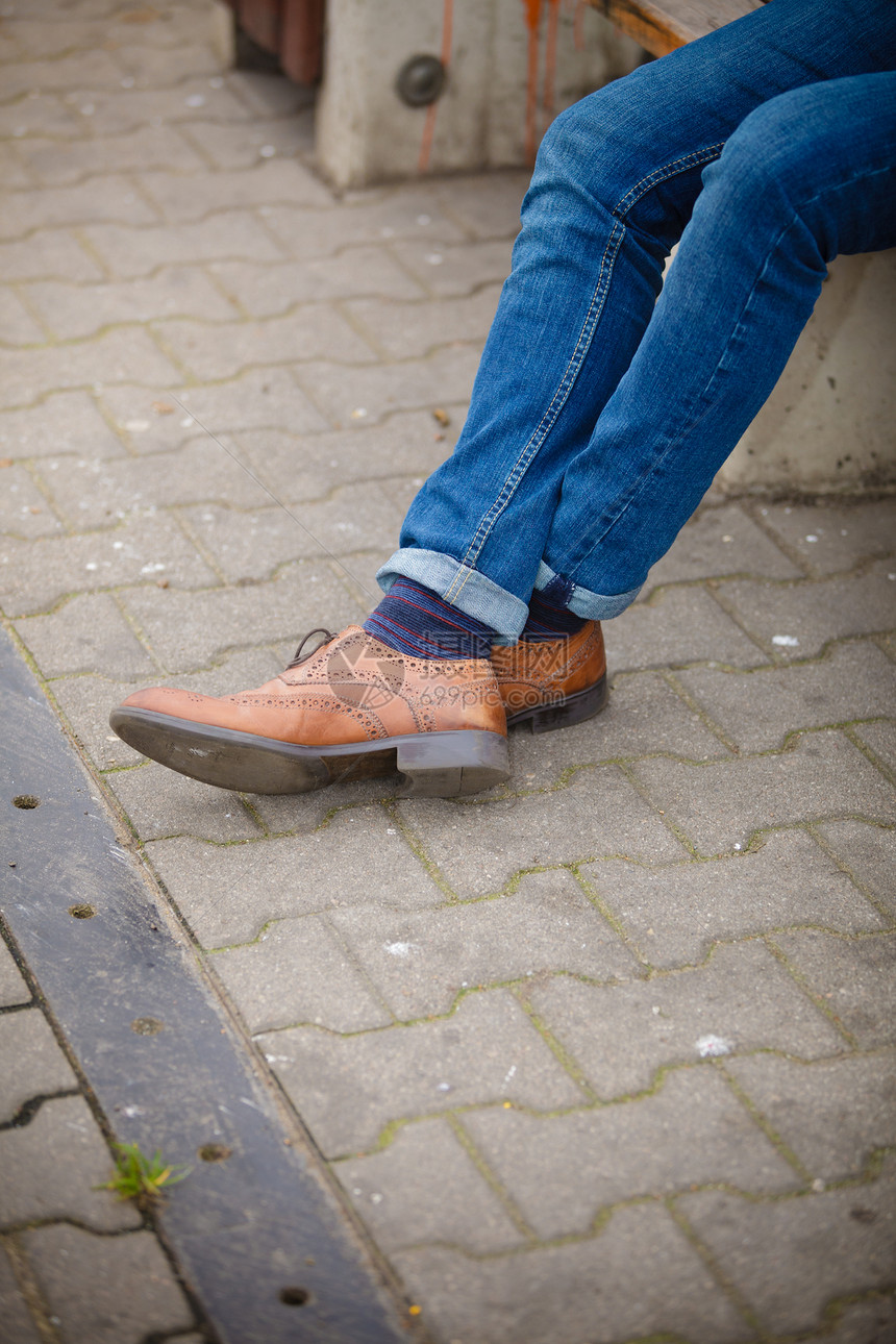 秋季时装脚穿鞋露在外面街上穿牛仔裤和靴子脱袜的男腿图片