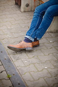 秋季时装脚穿鞋露在外面街上穿牛仔裤和靴子脱袜的男腿背景图片