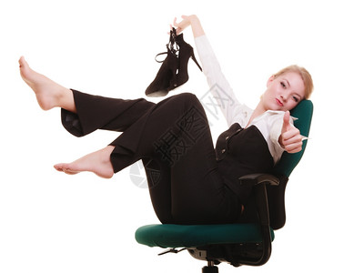女商人手拿着鞋子坐在椅上放轻松拇指在白色上被孤立图片