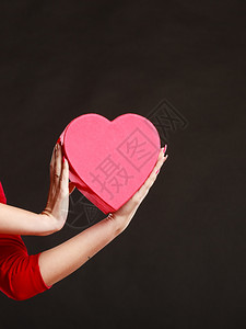 情人节爱浪漫概念女手拿着深灰色背景的心形礼物盒图片