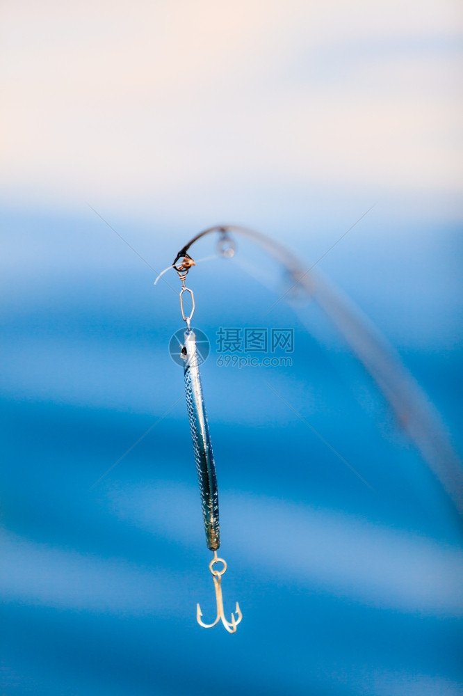 钓鱼饵与游击手对蓝海水表面的棍棒图片