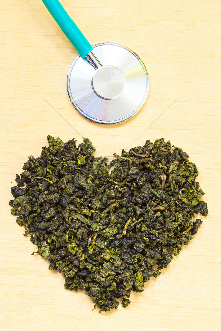 绿色茶叶心在木表面形成听诊器健康饮食以降低心脏病风险图片