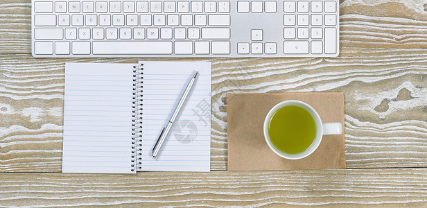 用键盘绿色茶杯笔记本和等横向格式的白色旧桌面顶部视图图片
