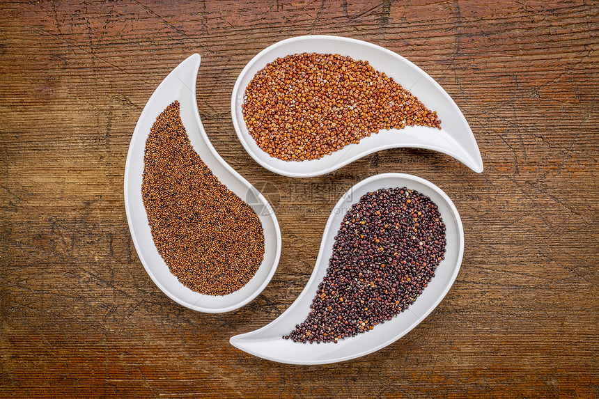 Kaniwa红色和黑的quinoa三颗无谷质的颗粒用催泪水制成的碗来对付锈木图片