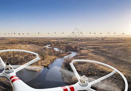 一架小型的无人驾驶飞机飞越河流图片