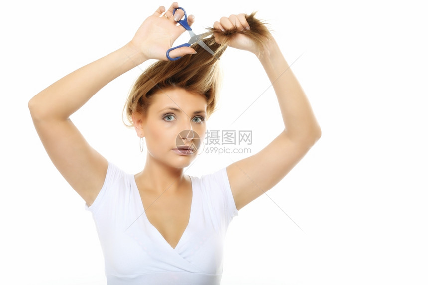 年轻的金发女郎用剪刀头发图片