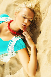 度假旅行和自由概念美丽的金发女孩躺在沙滩上肖像高清图片