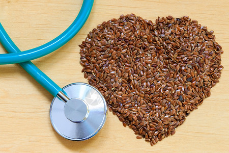 饮食保健与检查概念原始的麻籽菜心形和听诊器预防心脏病的健康食品图片