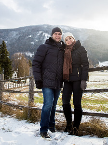 美丽的一对相爱笑情侣假扮着面对被雪覆盖的奥地利阿尔卑斯山图片