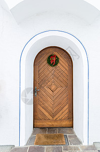 圣诞活动入口图由圣诞花圈装饰的美丽旧木门背景