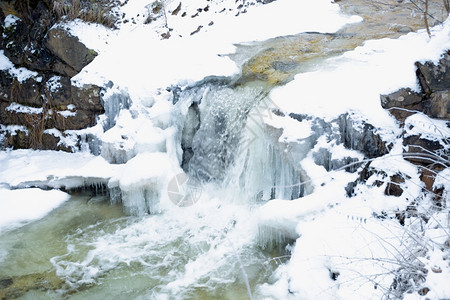 冬季高山快河上美丽的瀑布图片