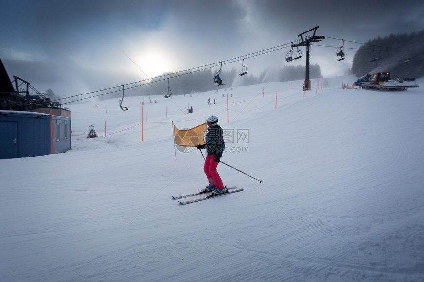 年轻妇女在奥地利滑雪度假胜山坡下骑车图片