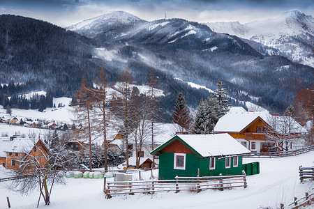 雪覆盖的高山上传统木屋的美丽景观图片