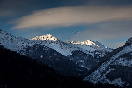 在雪覆盖的山顶上闪耀着美丽的太阳景色图片