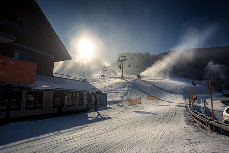 奥地利阿尔卑斯山丘脚的雪地传统旅馆所覆盖的山脚图片