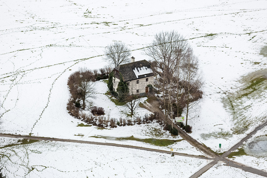 奥地利雪覆盖的田野中孤独房屋的空观察图片