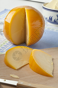 整片黄色圆环爱达姆奶酪切片在割板上图片
