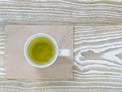 绿色茶叶饮料的顶端景象用纸巾以水平格式在白木表面的旧纸巾图片