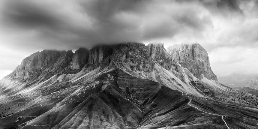 意大利多洛米人Sassolungo山峰的黑白全景图片