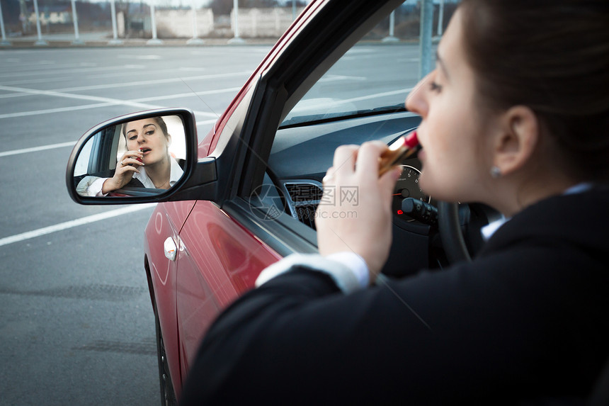 坐在车里涂口红的漂亮女商人图片