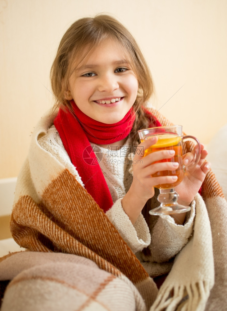 戴着围巾的笑女孩肖像披着一格装热茶杯的子图片