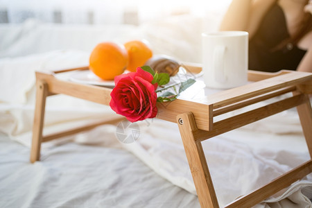 在旅馆房间的床上用早餐和红玫瑰的托盘早餐红玫瑰合照图片