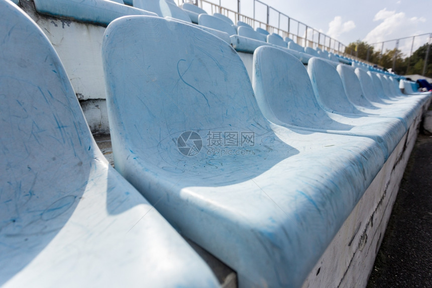 在空体育场上各排旧塑料座位的近距离拍摄图片