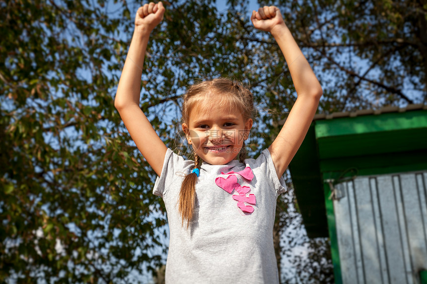 快乐的小女孩肖像在阳光明媚的白天在公园拉手图片