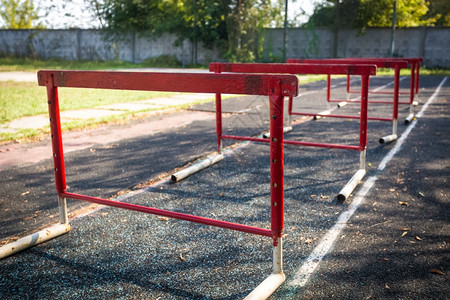 在废弃体育场进行障碍赛的一排旧红色障碍背景图片