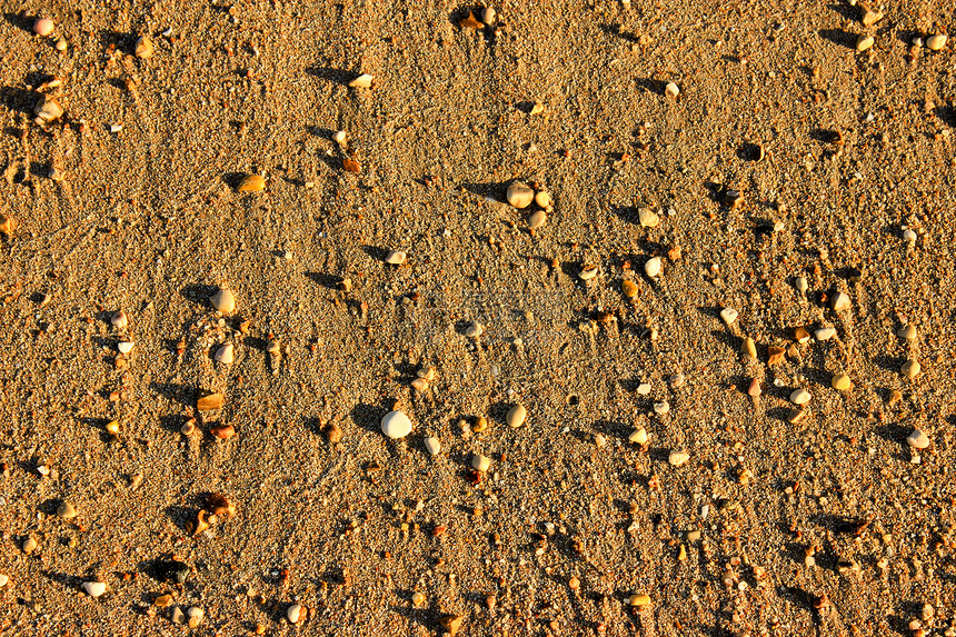 日落时的海滩泥背景棕色海沙子和太阳光的石头图片