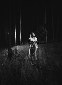 身着白衣妇女夜在森林中走着灯光的黑白妇女照片图片