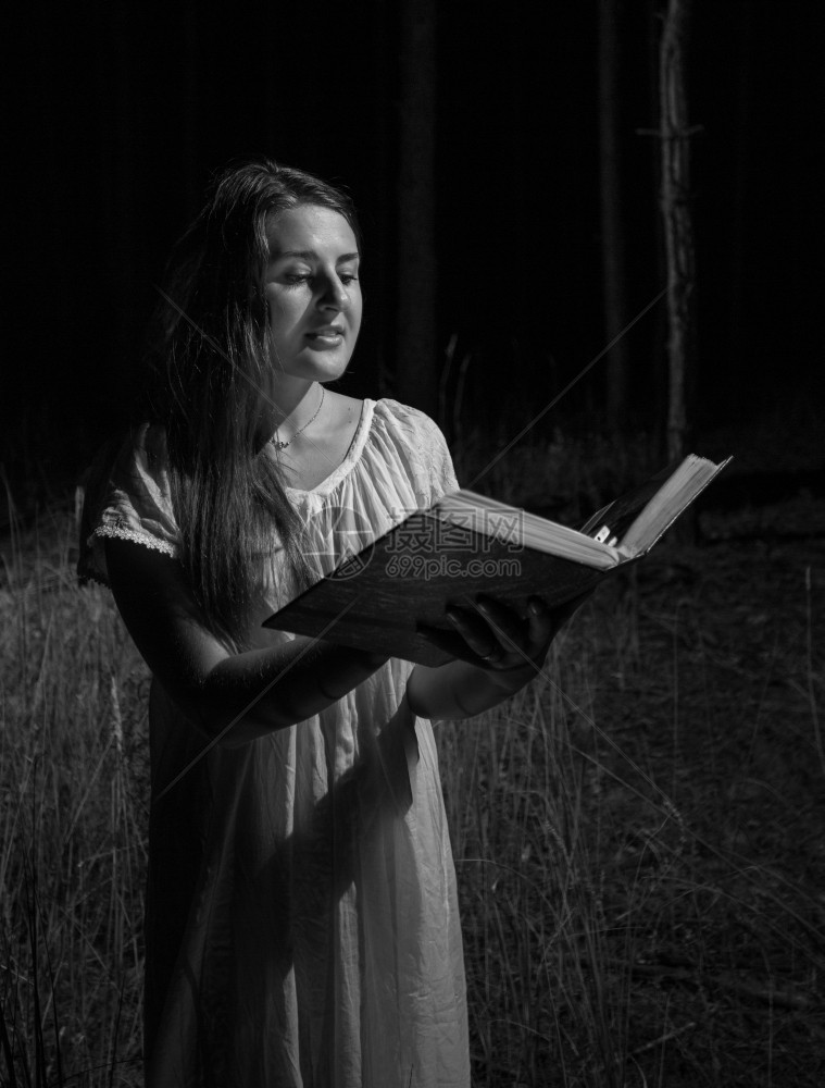 黑白女人在夜林里拿着大旧书的黑白女人肖像图片